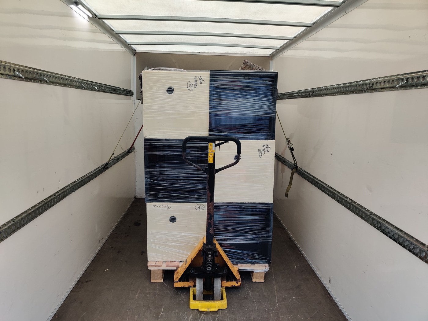 Pallet secured with ratchet straps and load-lock bar inside QM Transport van